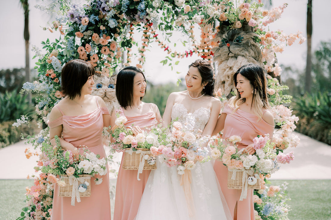 Bride and Bridesmaids pose near floral arch with cat decorations