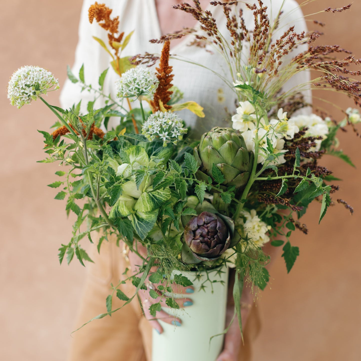 Bouquet of flowers held by a person against a neutral background