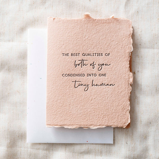 Pink card with a textured surface that reads, "The best qualities of both of you condensed into one tiny human."