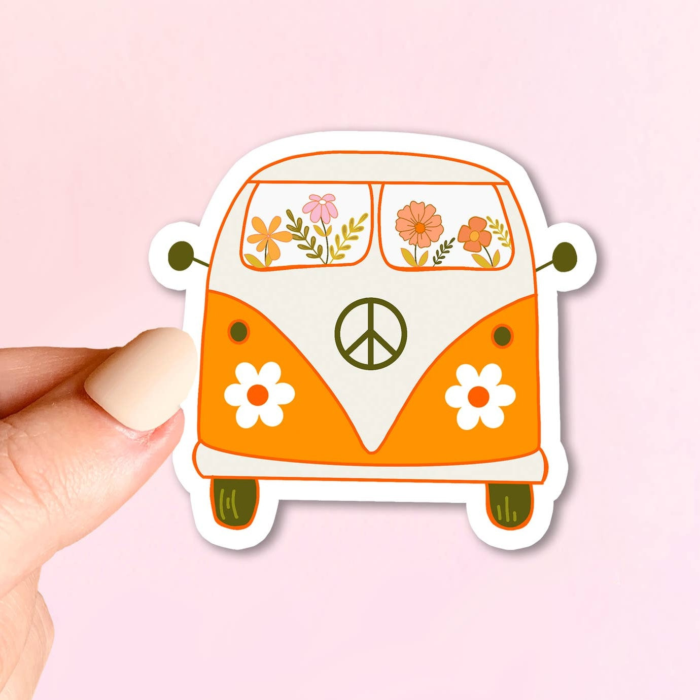 Sticker of a vintage van with flowers and a peace symbol held by a hand on a pink background