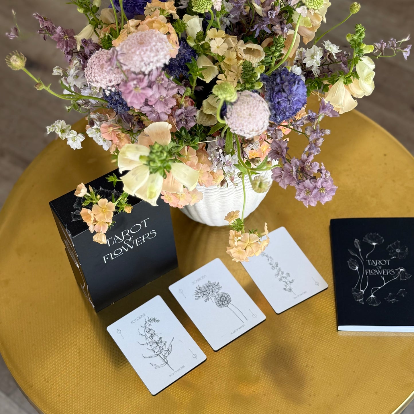 Floral tarot cards next to floral arrangement