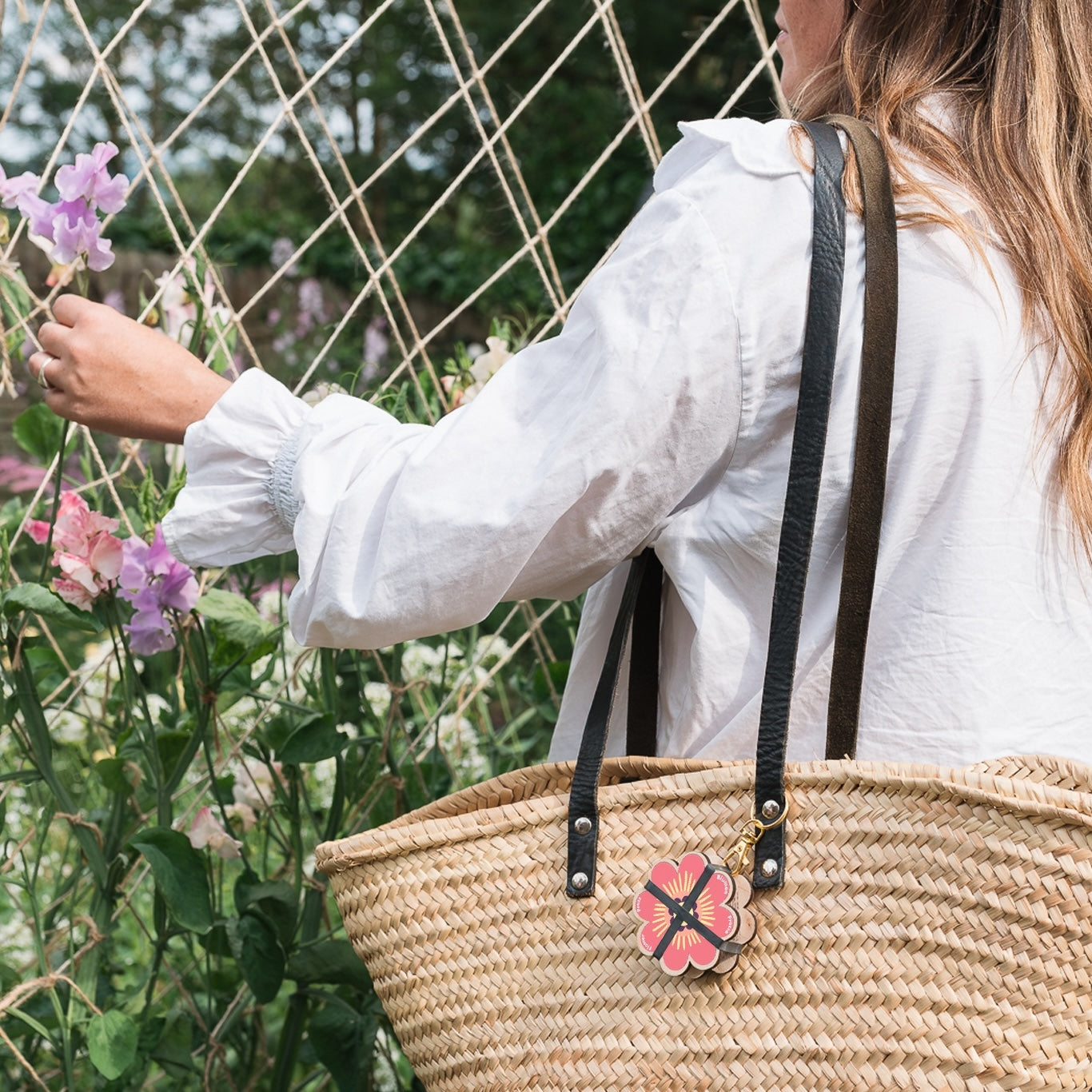 Portable Keyring Flower Press attached to a woven purse strap