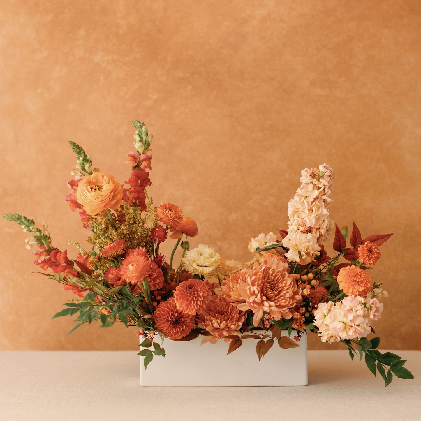 Thanksgiving Long & Low Arrangement with ivory, gold, peach, rust, and pink blooms