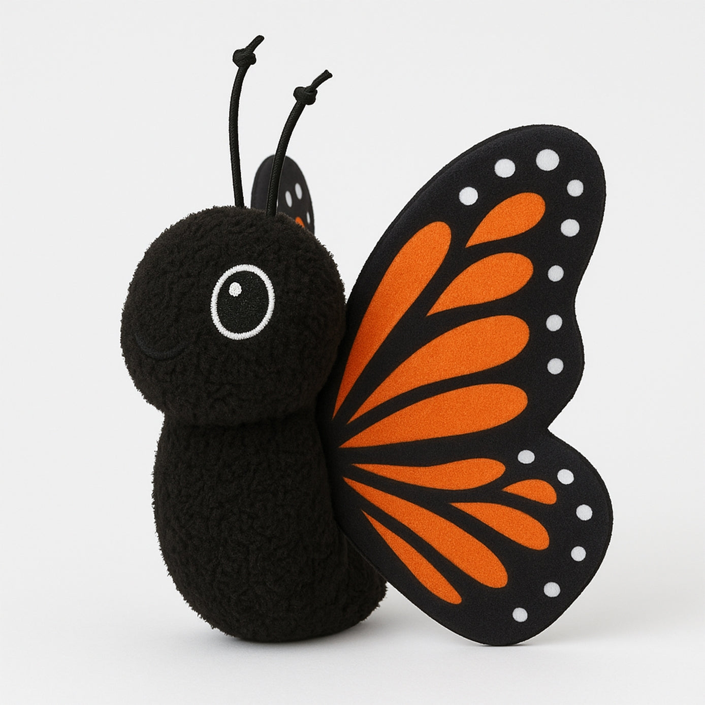 Butterfly-shaped plush toy with black body and orange wings on a white background