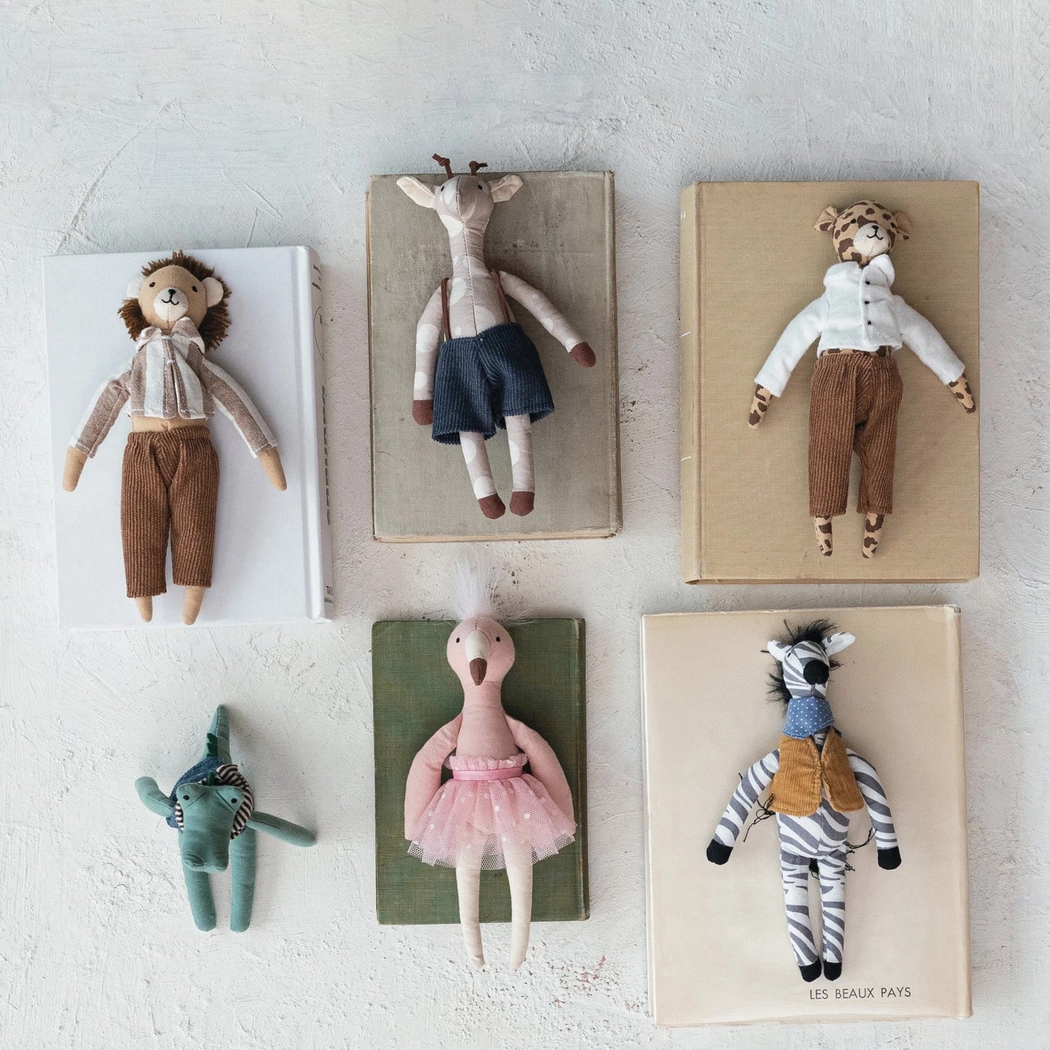 Set of handmade dolls on wooden boards against a light gray background