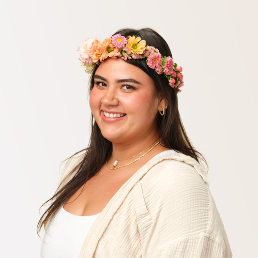 Woman wearing the Lucy Flower Crown in bright peach colors from Native Poppy