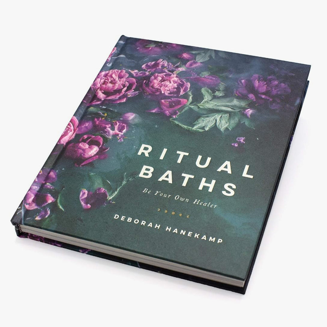 Book titled 'Ritual Baths' with floral design on a teal background