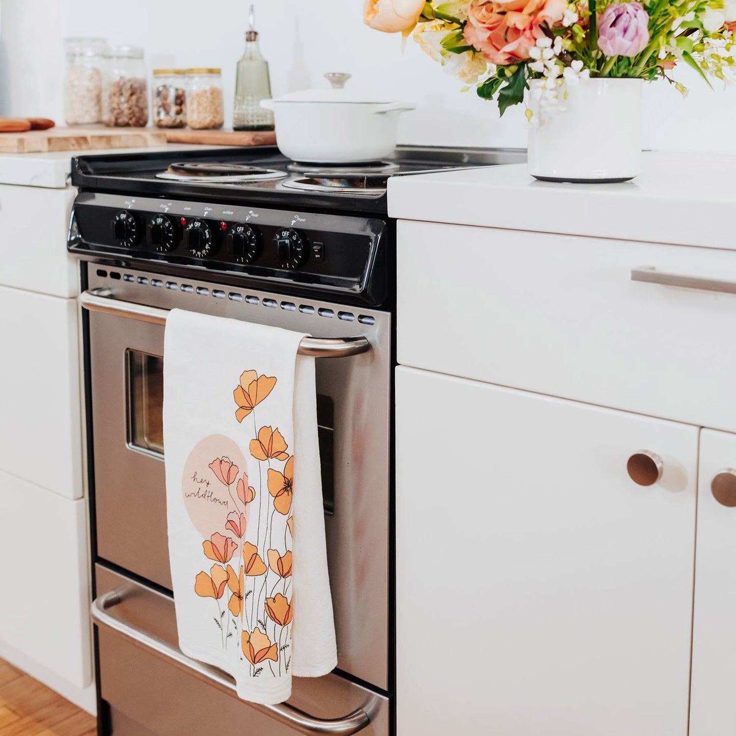 Hey Wildflower Native Poppy tea towel hanging on oven
