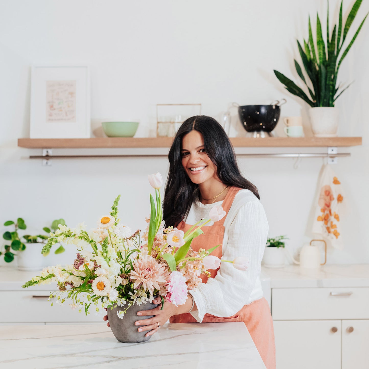 Woman holds a Grand flower arrangement from Native Poppy