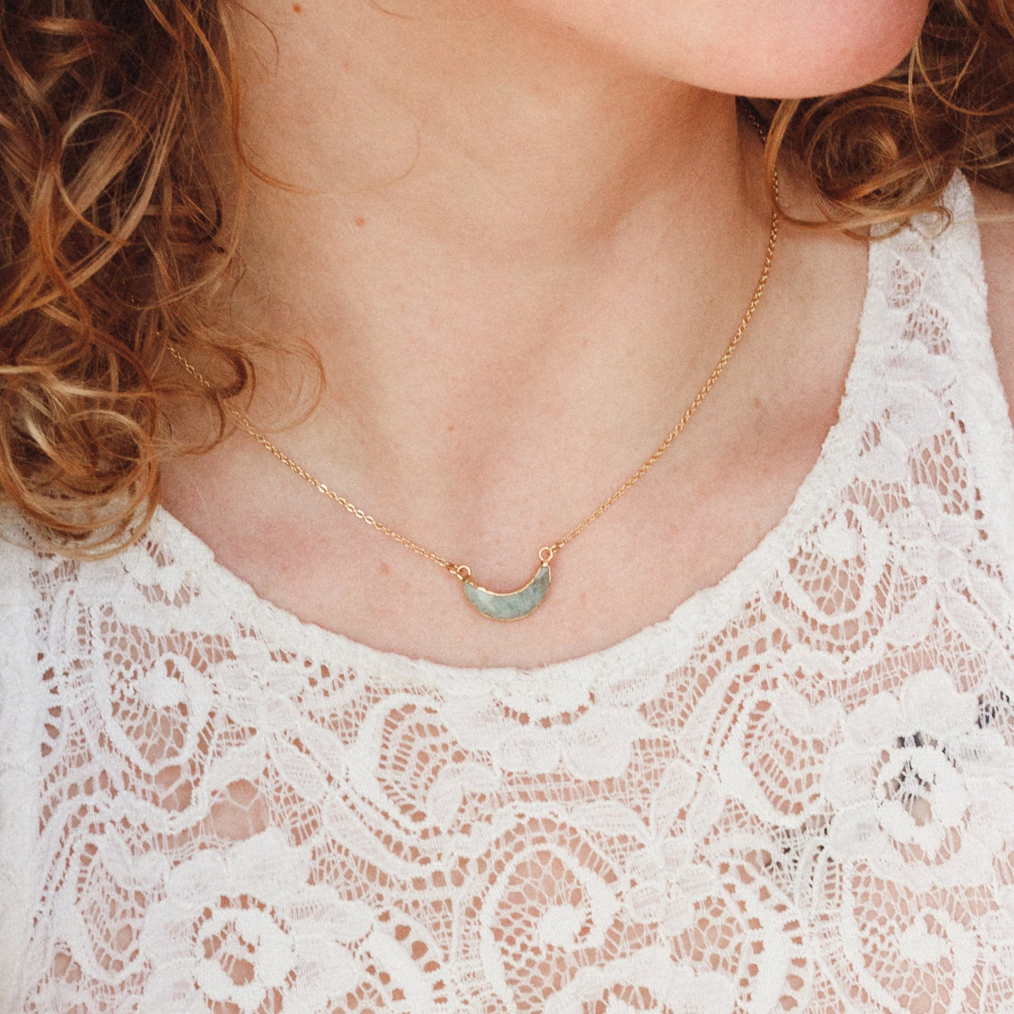 Woman with fair skin wears Eclipse Aquamarine Necklace from Luna Norte