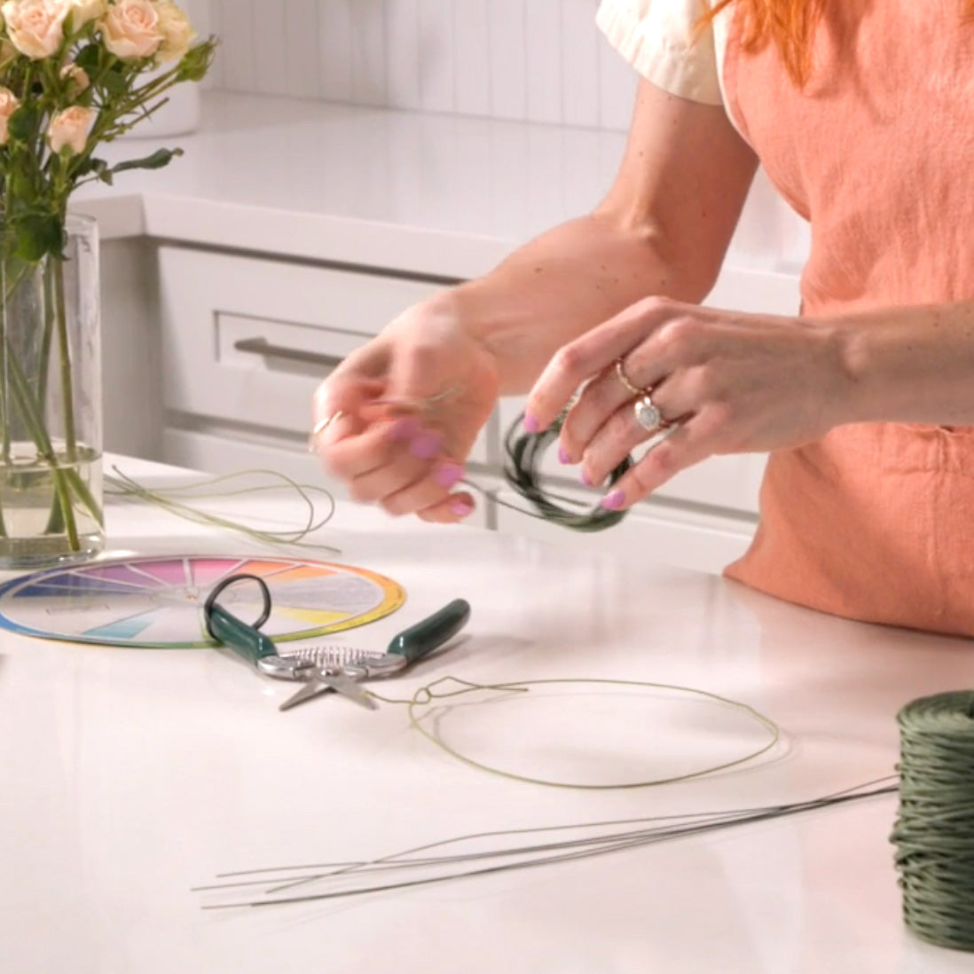 Florist wearing peach apron uses DIY Flower Crown Kit
