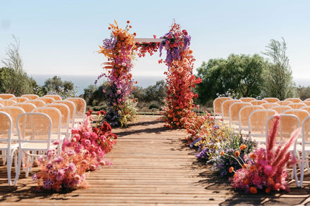 Rainbow floral chuppah with wild flower wedding aisle