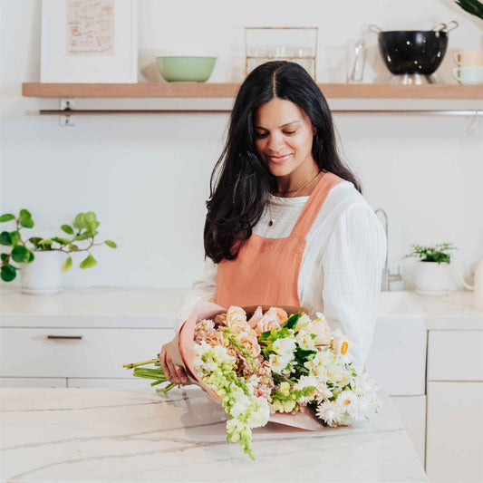 Woman placing down wrapped bouquet of flowers