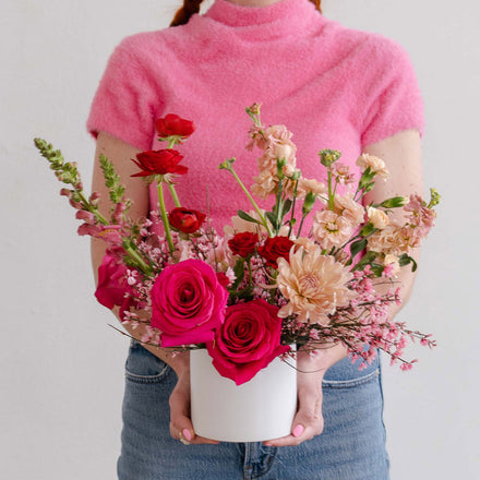 Woman in pink holding valentine's day flowers