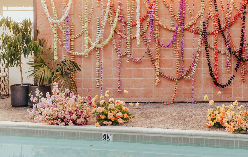 Carnation garlands and floral arrangement in poolside setting