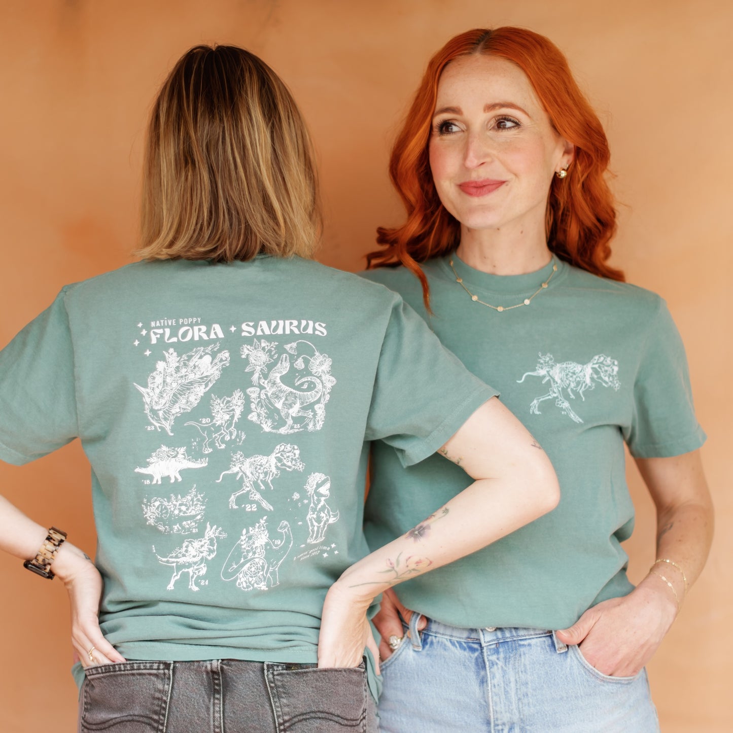 Two people wearing green t-shirts with white graphics on a beige background