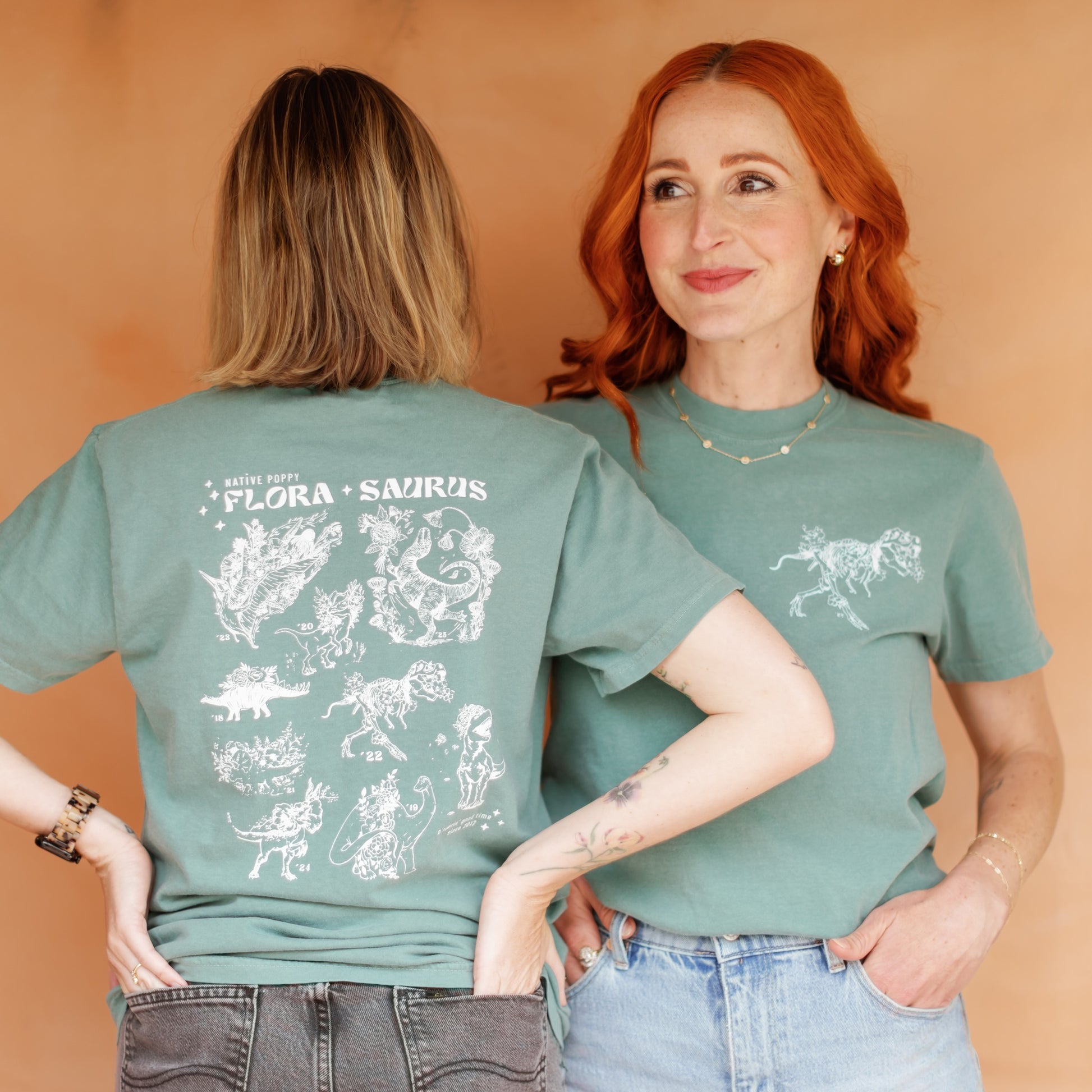 Two people wearing green t-shirts with white graphics on a beige background