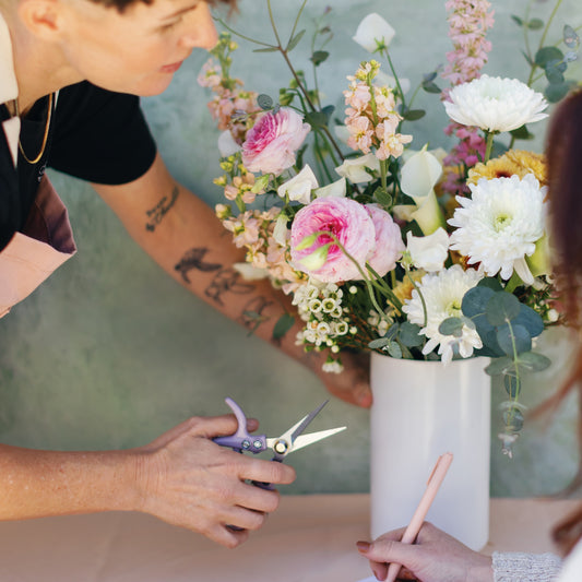 Jesse teaching a tall flower arrangement workshop