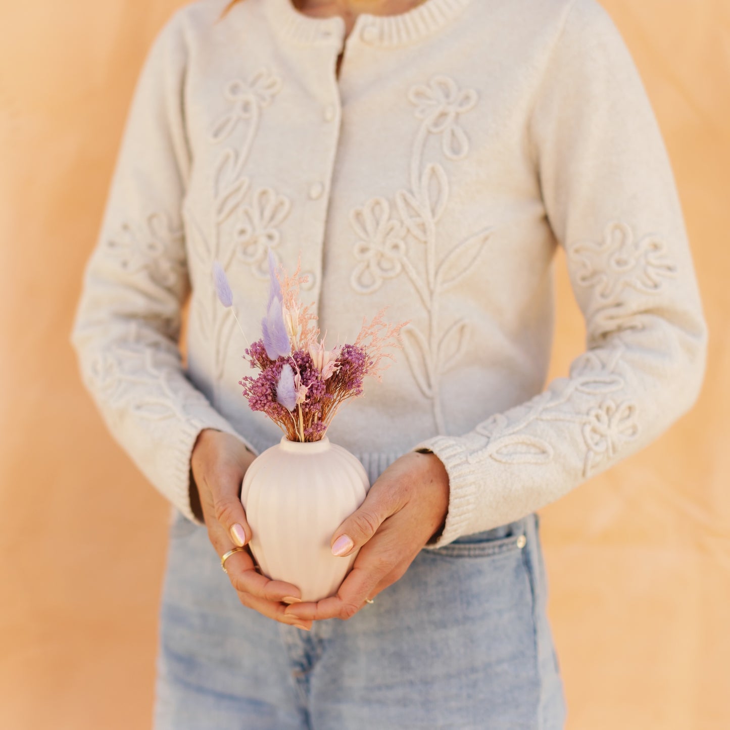 bud vase arrangement held by a woman