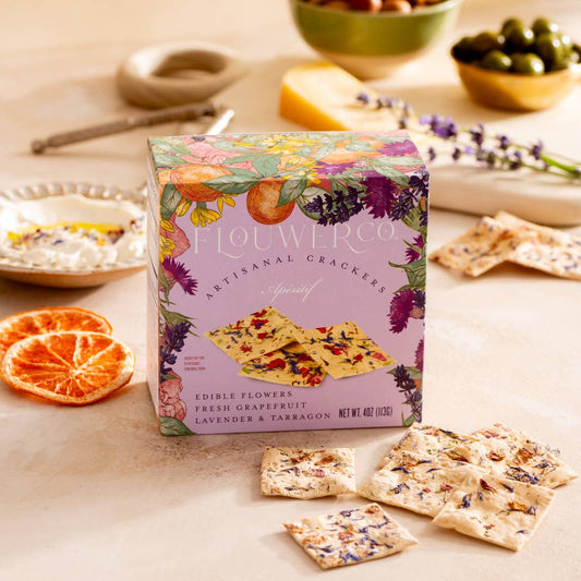Box of Flouwer co Artisanal Crackers on a table with crackers and snacks.