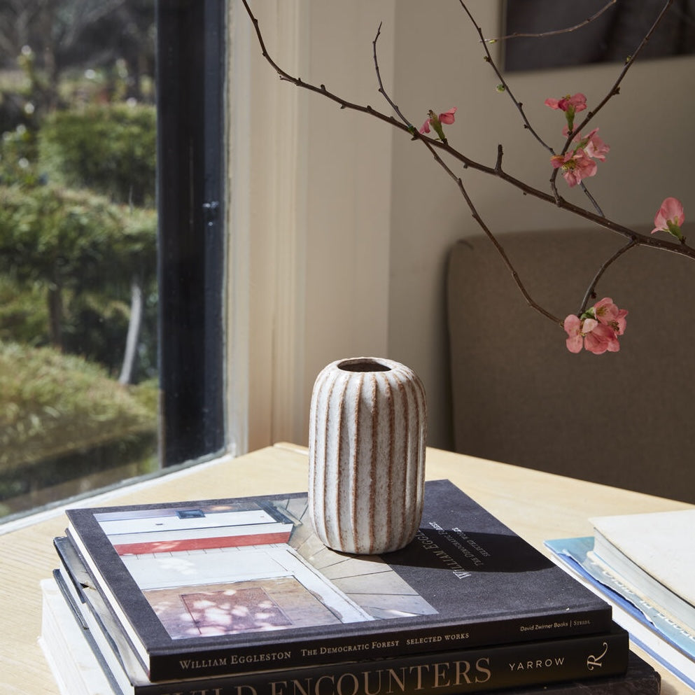 Short Ginger Ceramic Bud Vase on a table with books