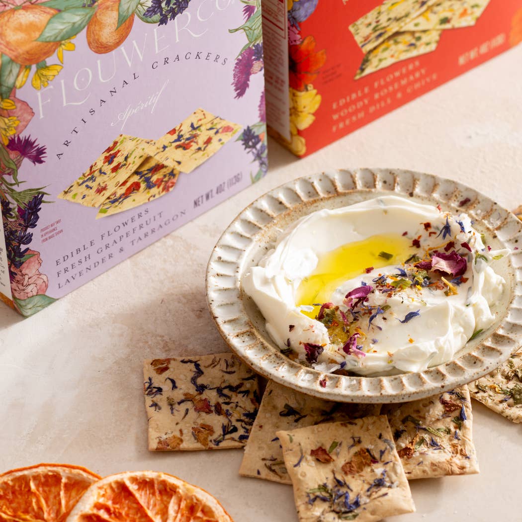 Flower crackers with a bowl of dip and flowers on a table