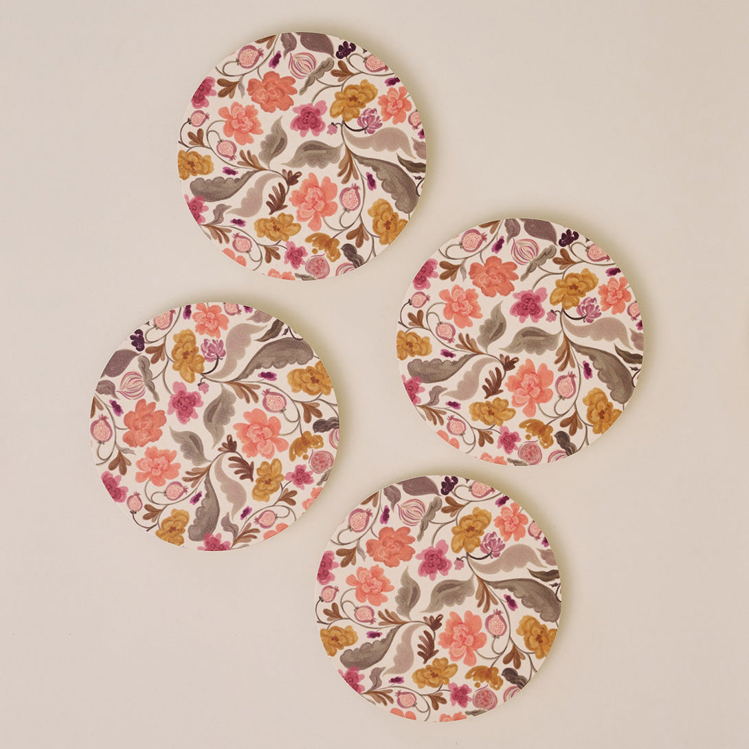 Four floral coasters with a beige background