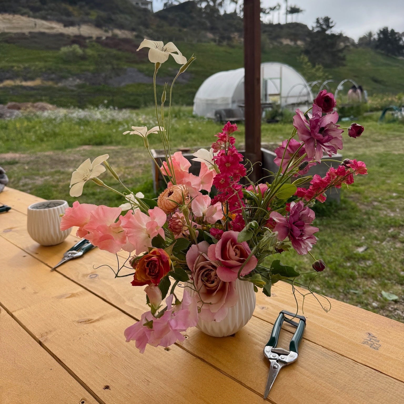 Floral arrangement in a vase on a wooden table at Beeworthy flower farm 