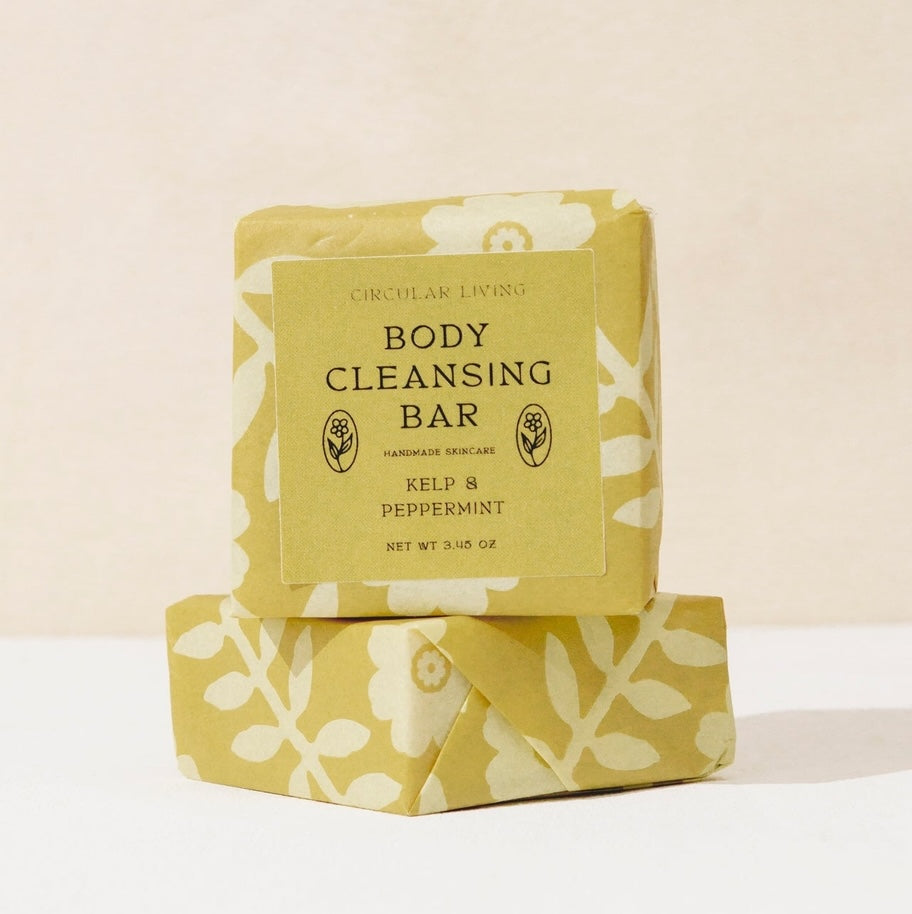 Body cleansing bar with floral packaging on a light background