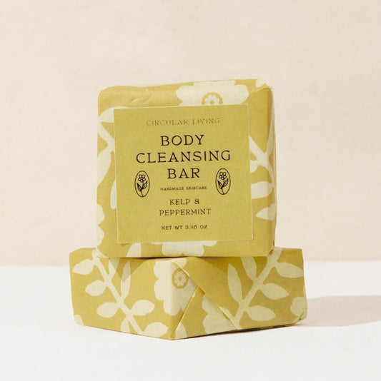 Body cleansing bar with floral packaging on a light background