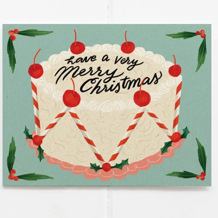 A little slice of holiday nostalgia. This cheerful Christmas card features a frosted vintage-inspired cake decked out with cherries, candy-cane stripes, and holly, all topped with a very merry message.
