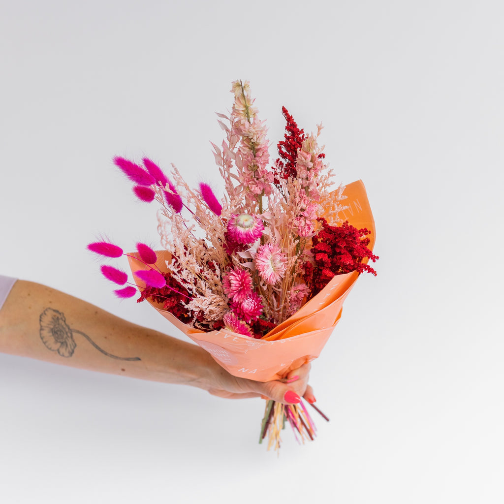 Red, pink, and peach dried flowers wrapped in paper