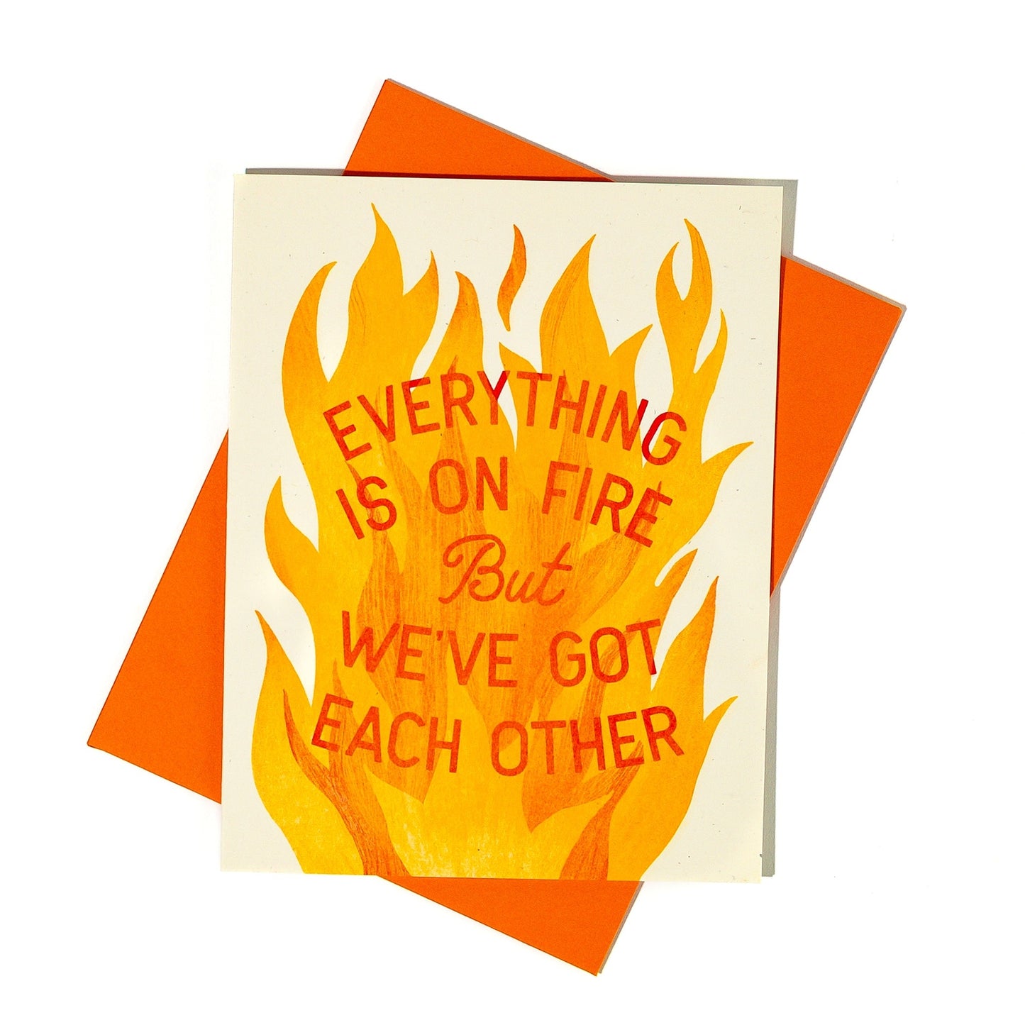 Card with flames and text 'Everything is on fire but we've got each other' on an orange envelope.