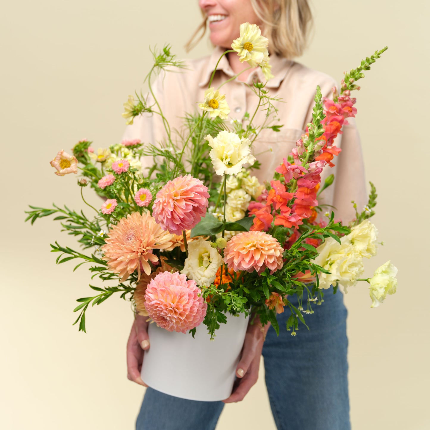 Natalie Gill holds an Extra flower arrangement in bright colors from Native Poppy