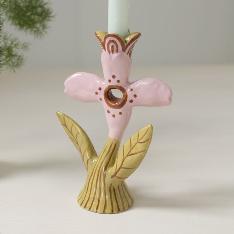Ceramic candle holder with pink flower and gold leaves on a white background
