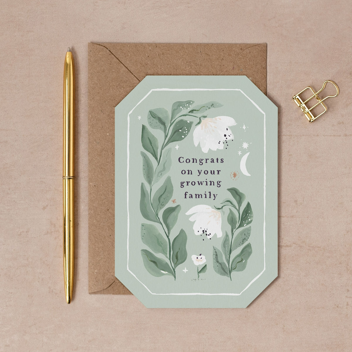 Greeting card with floral design and text 'Congrats on your growing family' on a beige background.