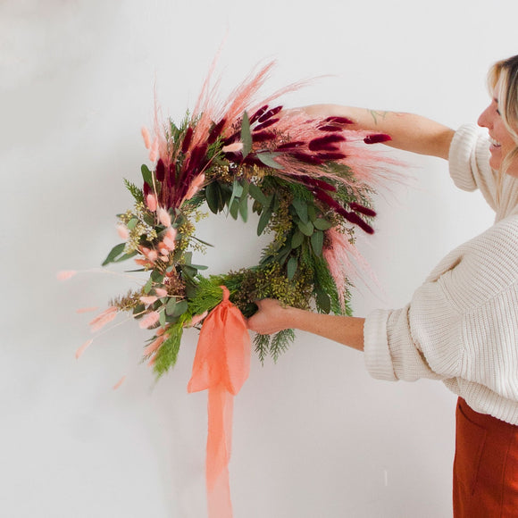 Natalie Gill holds Holiday Wreath at a Native Poppy Workshop