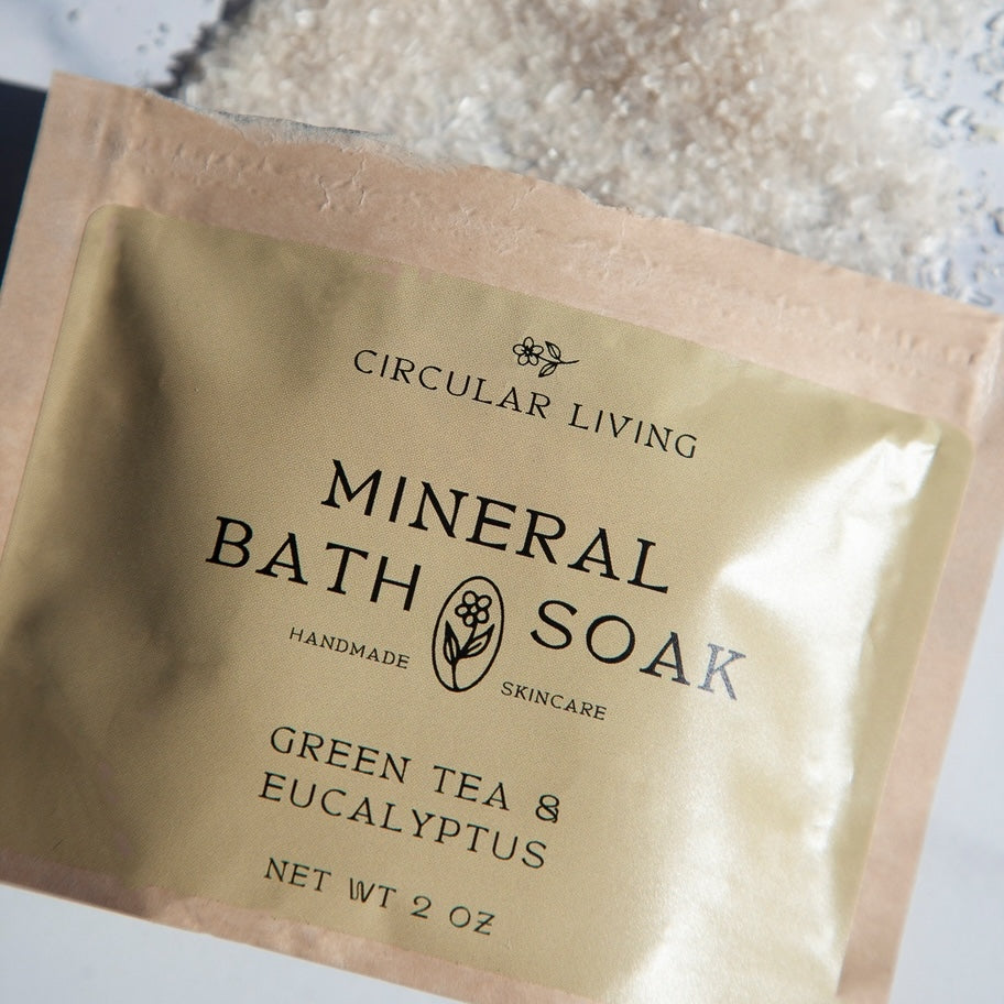 Package of Circular Living Mineral Bath Soak with Green Tea & Eucalyptus on a textured surface.