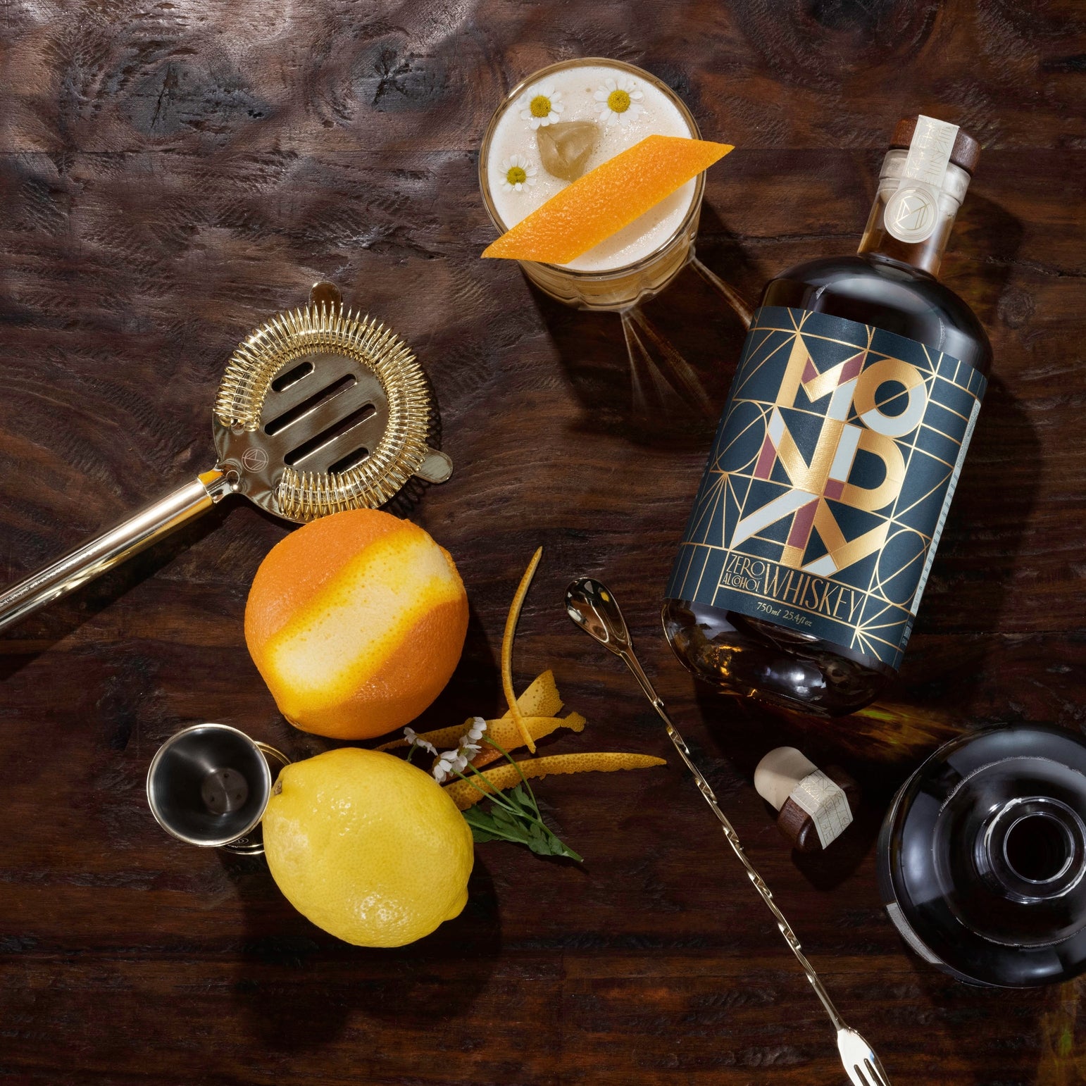 Bottle of Monday zero proof Whiskey with cocktail ingredients on a wooden surface