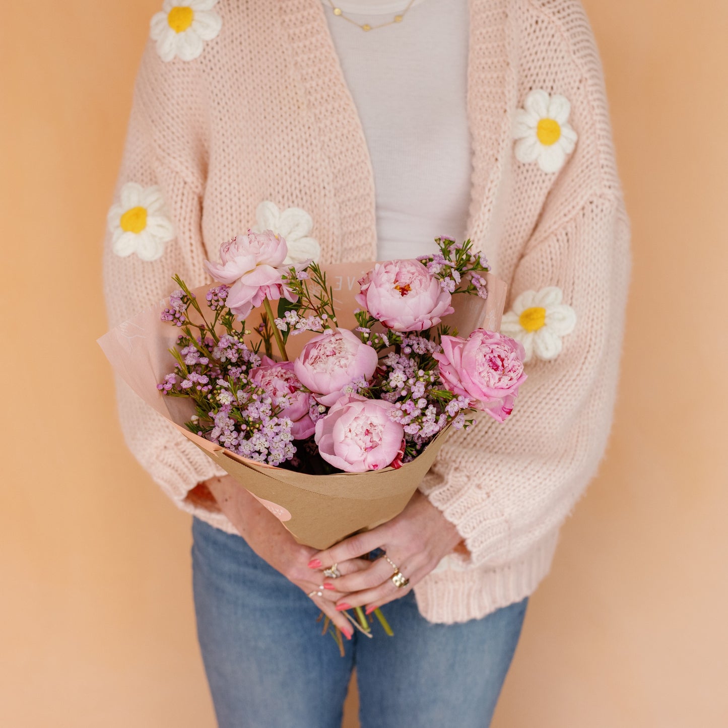 Woman holding Peonies wrapped in paper for Mother's Day