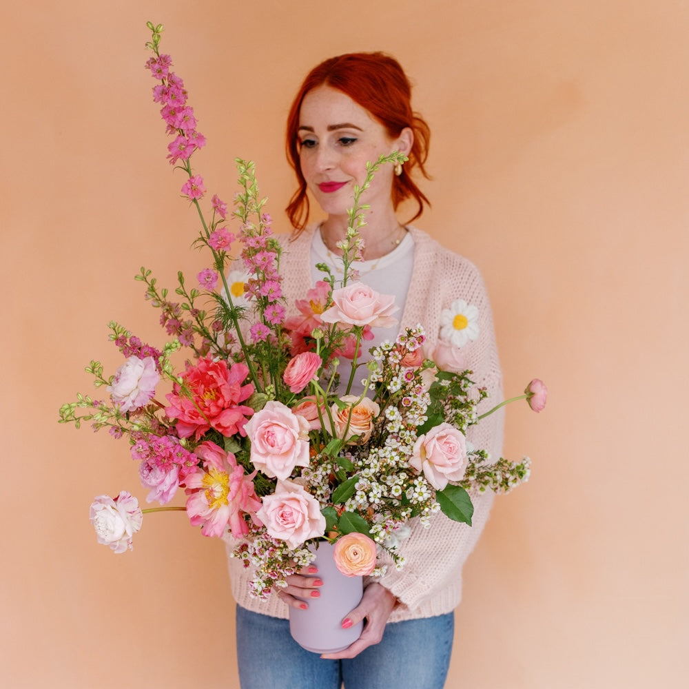 Woman in floral sweater holding Premium Mother's Day Flower Arrangement from Native Poppy