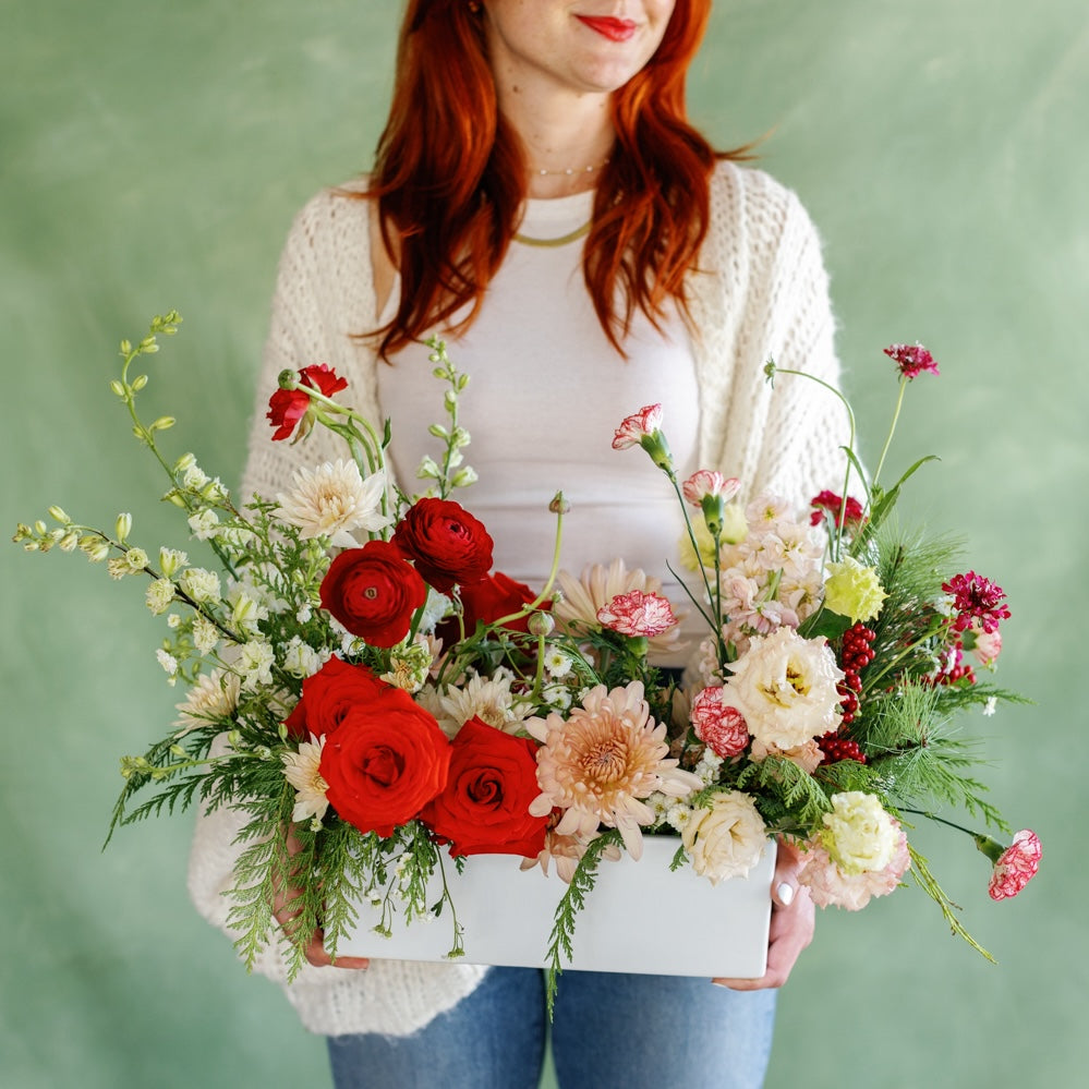 Meg holding a Holiday Long & Low Flower Arrangement from Native Poppy