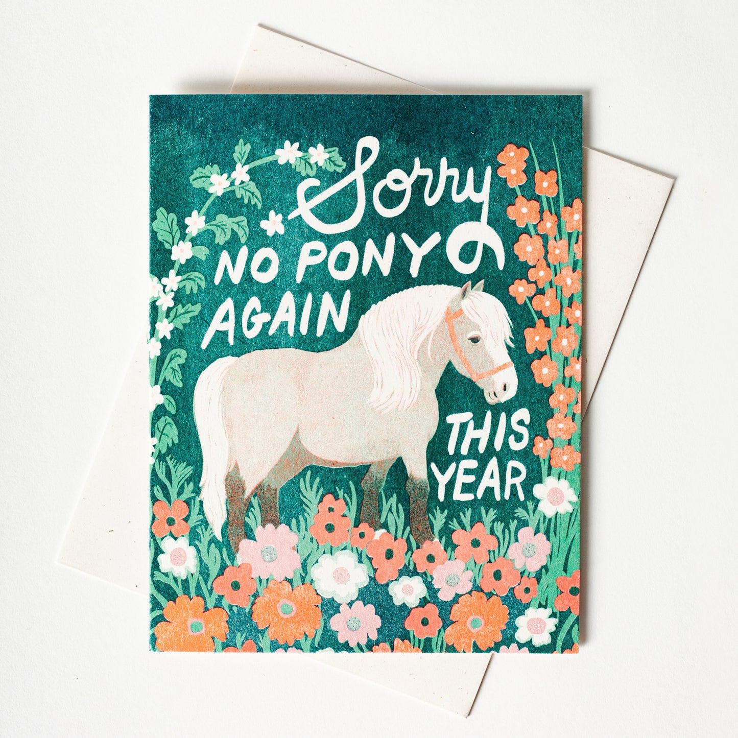 Card with a white horse illustration and floral design, featuring text 'Sorry no pony again this year' on a teal background.