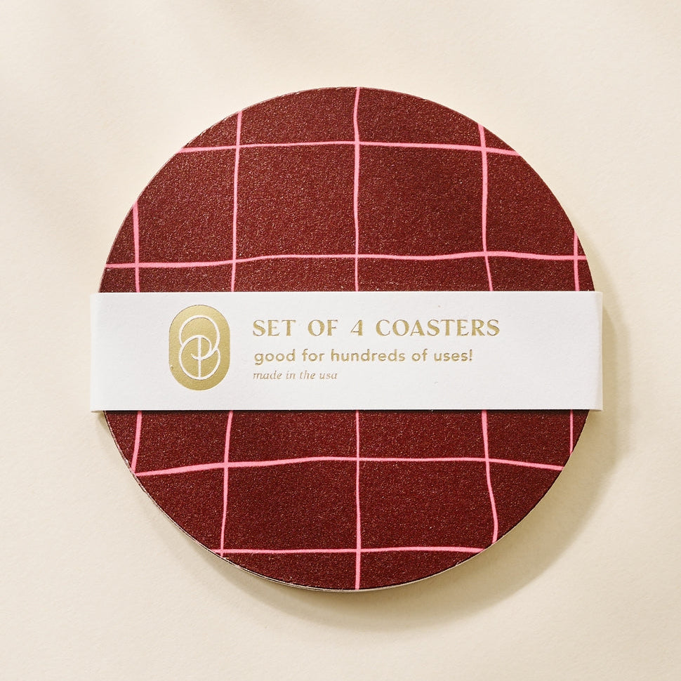 Pack of red checkered coasters with a white label on a beige background