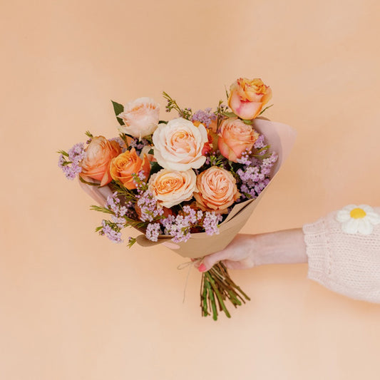 Peach roses and mini pink textural flowers wrapped in paper
