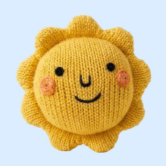 Knitted sun-shaped toy with a smiling face on a light blue background