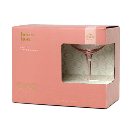 Pink packaging box with a wine glass inside, featuring the brand 'here's how'.