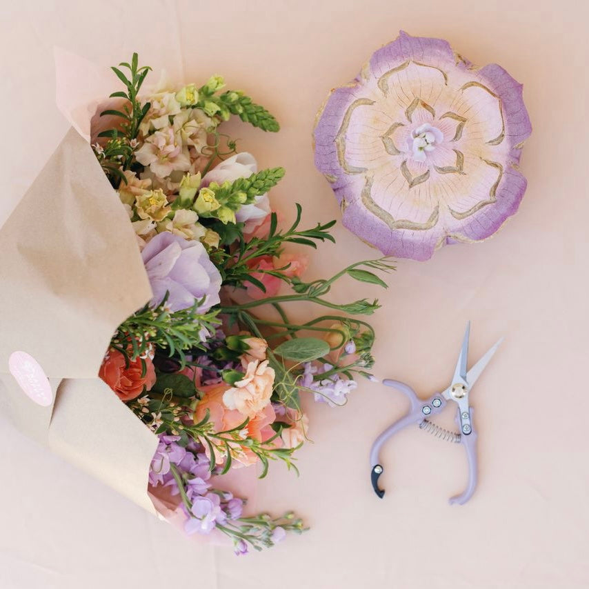 Flower bouquet next to a floral patterned sourdough loaf and floral snips