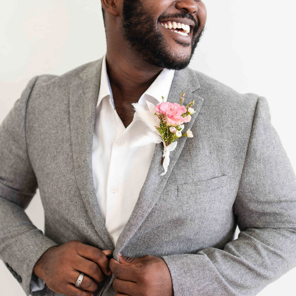 Man wearing grey suit with pink floral boutonnière