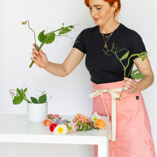 Woman arranging flowers with a white background
